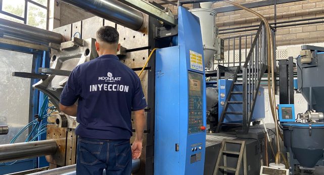 Operario de MOONPLAST trabajando en una máquina de inyección